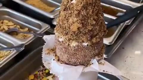 Ice cream served over a chimney cake with a cookie .