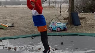 slo motion kid on trampoline falling on ice