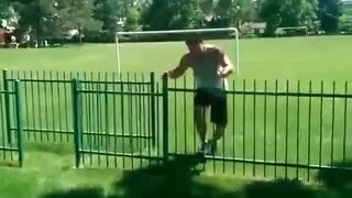 Guy jumps over metal gate and gets foot stuck on top of gate