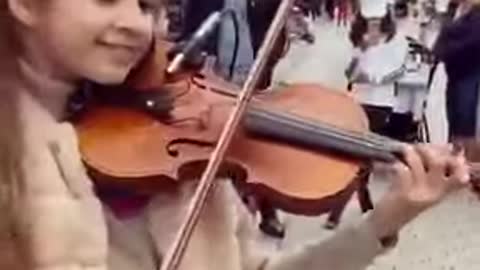 A little girl is totally amazed by her live violin performance