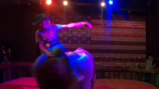 Mechanical bull riding in Las Vegas: a cowboy takes a rough ride but his hat gives him stamina