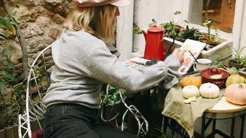 Young Woman Painting in Notebook