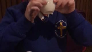 Boy in blue school uniform sweater spills drink