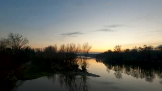 a-scenic-view-of-a-calm-river-at-dawn