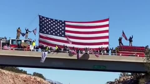 Freedom Convoy USA - People in Arizona greeting truckers with a giant US flag