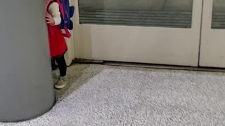 Adorable Toddler Girl playing peek-a-boo at airport will make your day