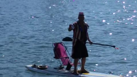 Guy dressed like uncle sam paddleboards on lake