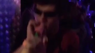 Music guy with dark glasses on in club plays with yellow toy