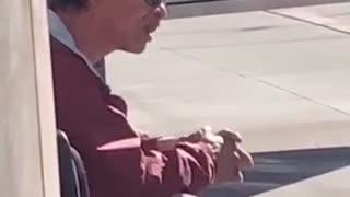 Guy flicks his tongue up and down waiting for bus stop