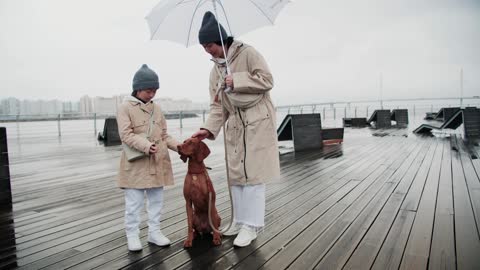 A Mother and her Daughter Posing with their Dog