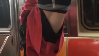 Man red sweater upside down on subway rail