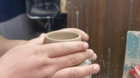 a ceramic cup is made by hand.