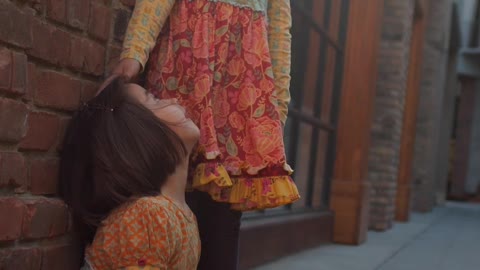 Two Girls Wearing Floral Dresses Playing Outside