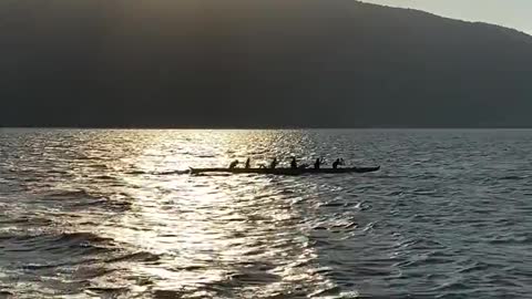 Silhouette of People in a Canoe in the Sea