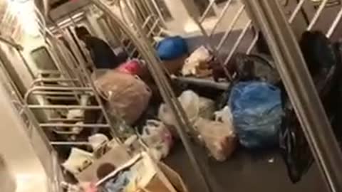 Homeless man puts all his trashbags and belongings inside a subway train