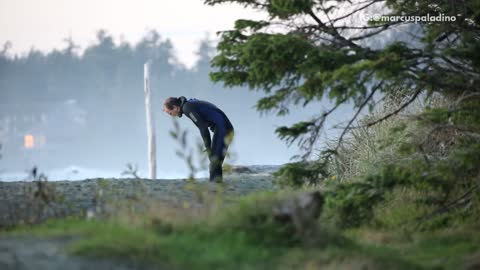 Wet suit guy does deep knee bends to warm up