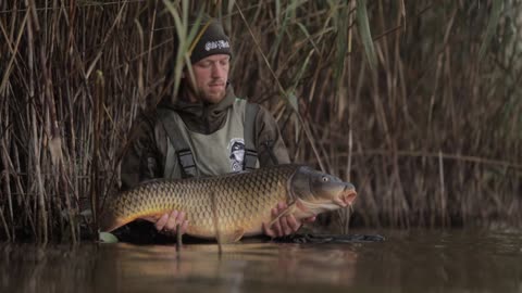 A man with a live fish in hand