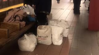 Homeless person spraying air freshener around hobo fort in subway
