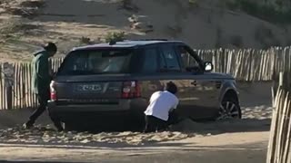 Guys get car range rover stuck in sand try to get it out