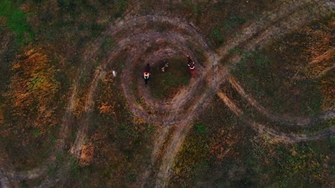 Two horses with equestrians are going in circle on the autumn field