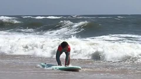 Girl surfing waves knock her down
