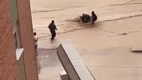 Mother tries to cross floodwaters with her child in a stroller