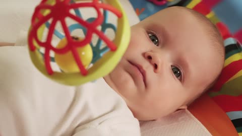 Little baby playing with his hanging toy