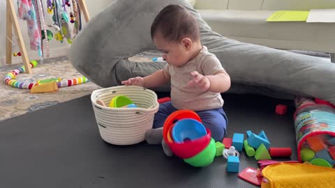 Baby plays with stacking cups 6 mo