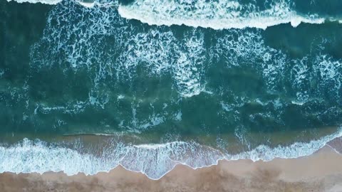 Aerial view of sand beach. Top view sea waves. Drone footage