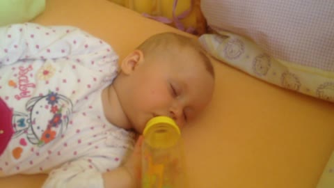 Sleepy baby falls asleep while drinking bottle