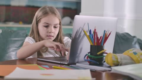 little girl studying on a computer