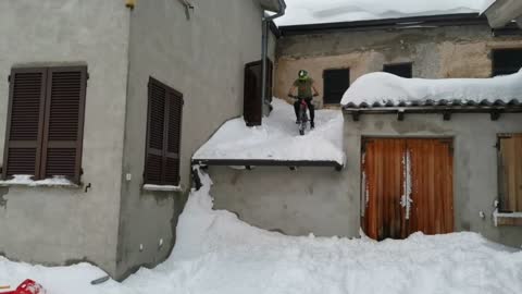 Man Attempts To Jump Off Snowy Roof With A Mountain Bike But It Goes Wrong