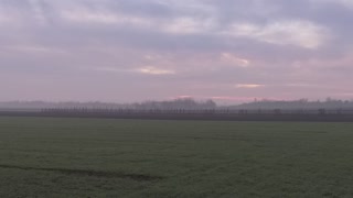 Train passes by romanian countryside on a foggy morning.