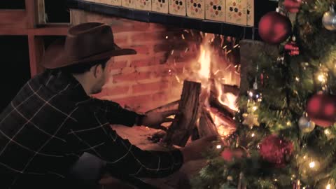 Man feeds the fire from his fireplace