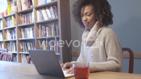 Casual student woman sitting at coffee shop and using laptop