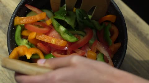 Close Up of Female Hands Mixing Salad Bowl Contents-Close-up shot of a pair of female caucasian hand