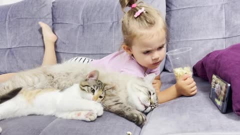 Baby_Girl_With_Cats_Eating_Popcorn_and_Watching_Cartoons