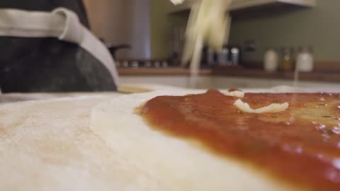 Close Up Sprinkling Cheese on Pizza Dough