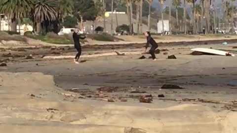 Two people tossing ball back and forth at the beach