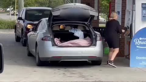 Blond wants to fill the Tesla electric car and looks for the tank door😆😆
