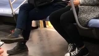 Hoodie guy looking at phone picks own booger and eats it on subway