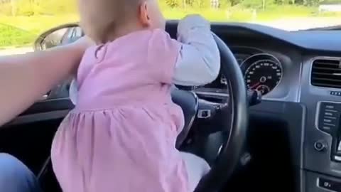 Cute baby driving the car on its own