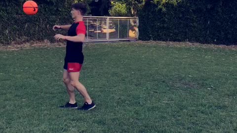 Kid in red and black kicks ball lands on back neck