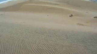 Go pro blue board surfs sand dune falls down