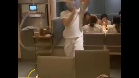 Enthusiastic restaurant worker dances while pulling one-strand noodle in Vietnam