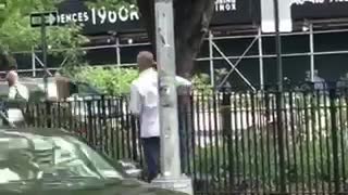 Man in white spinning a broom on street
