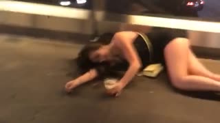 Two girls in black dresses in vegas one falls over on railing on bridge
