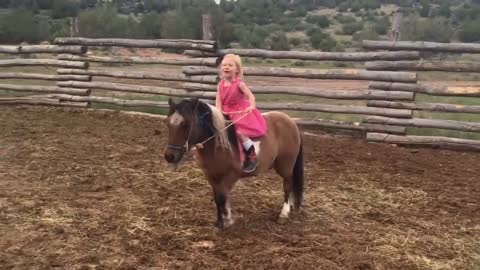 Little Girl Rides and Sings with Her Pony