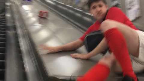 Guy Falls From An Escalator