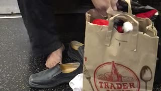 Man with shoes white socks off trader joes bag